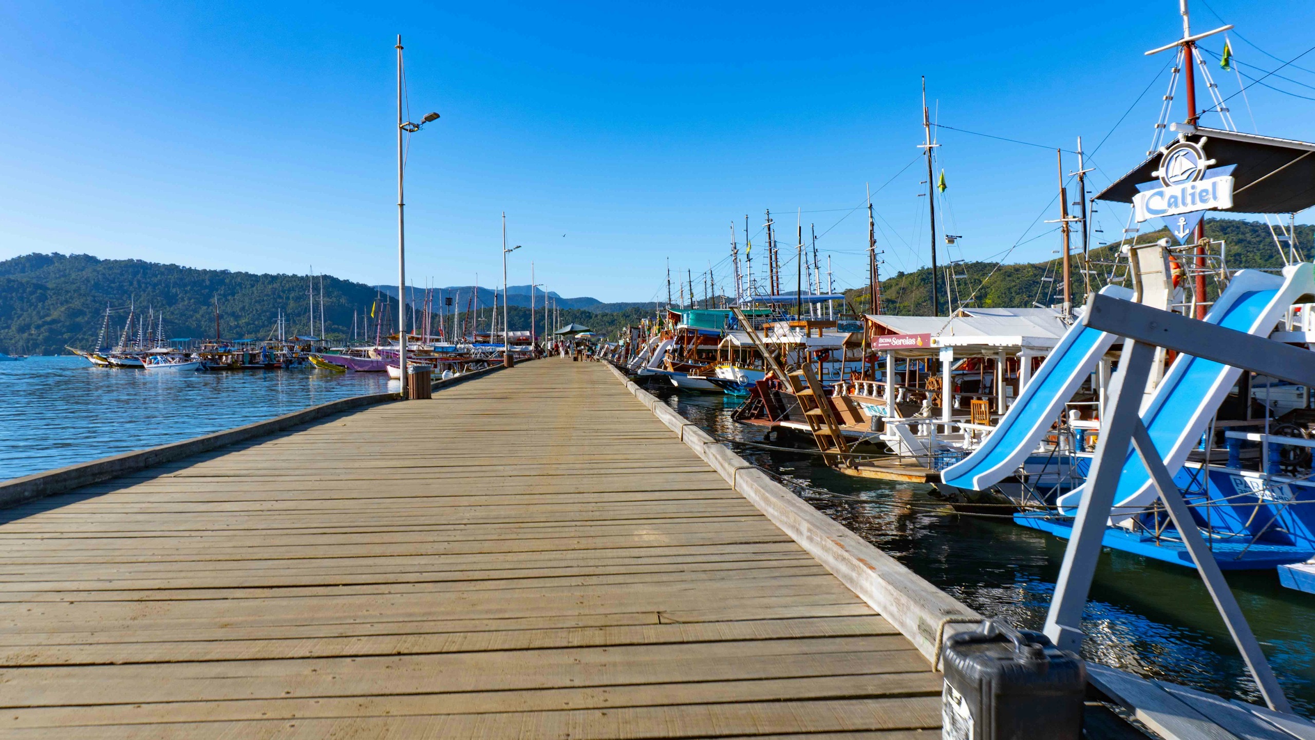 Il pontile di legno che entra nel porto, fra le barche ormeggiate.