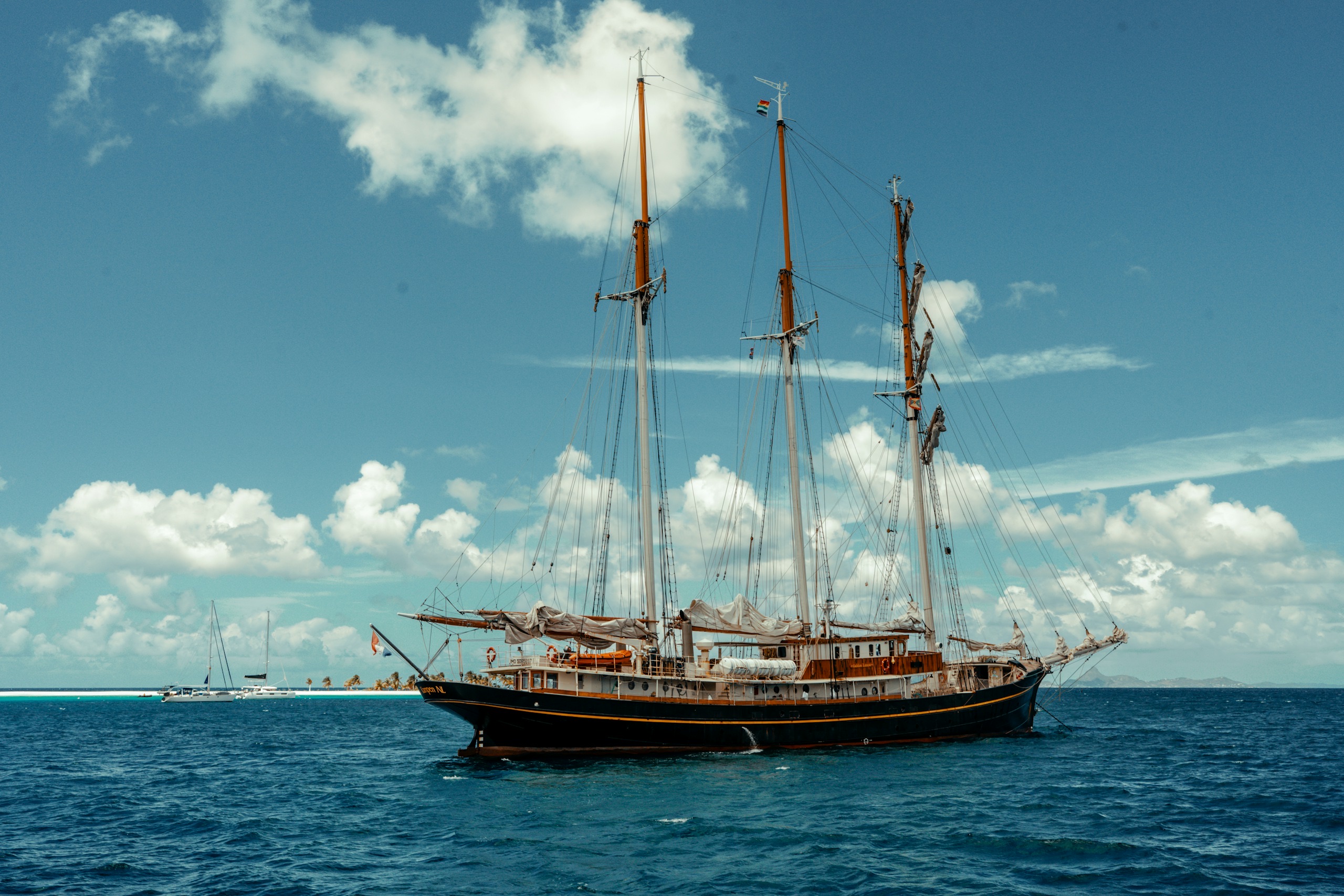 A large classic sailing ship, under full sail.