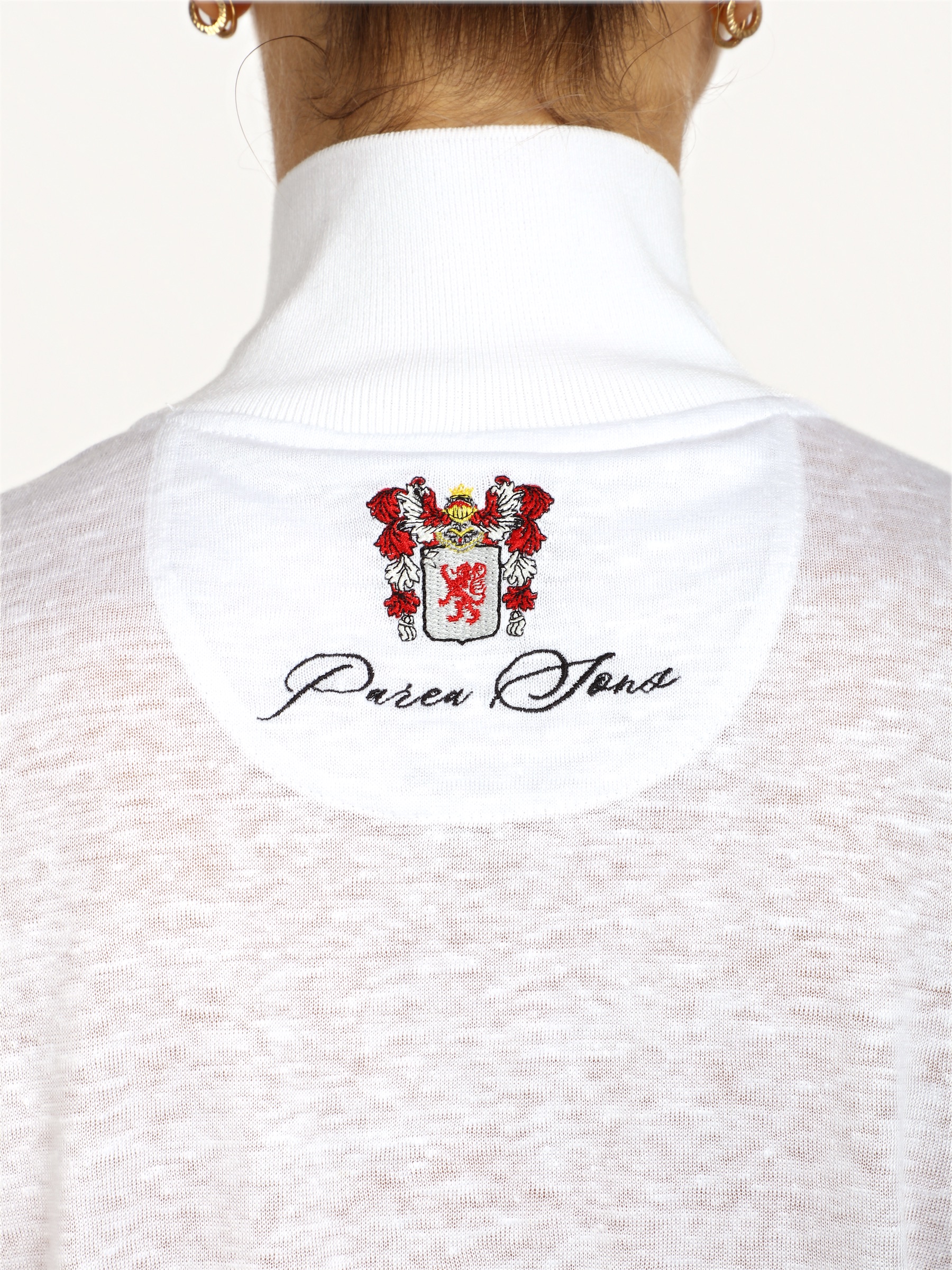 The crest embroidered on the white sailor jacket, stitch by stitch.