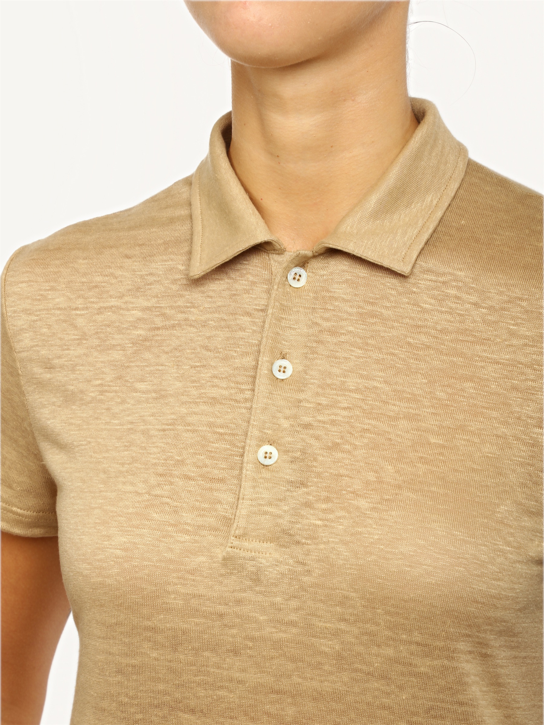 The mother-of-pearl buttons on the beige polo, up close.